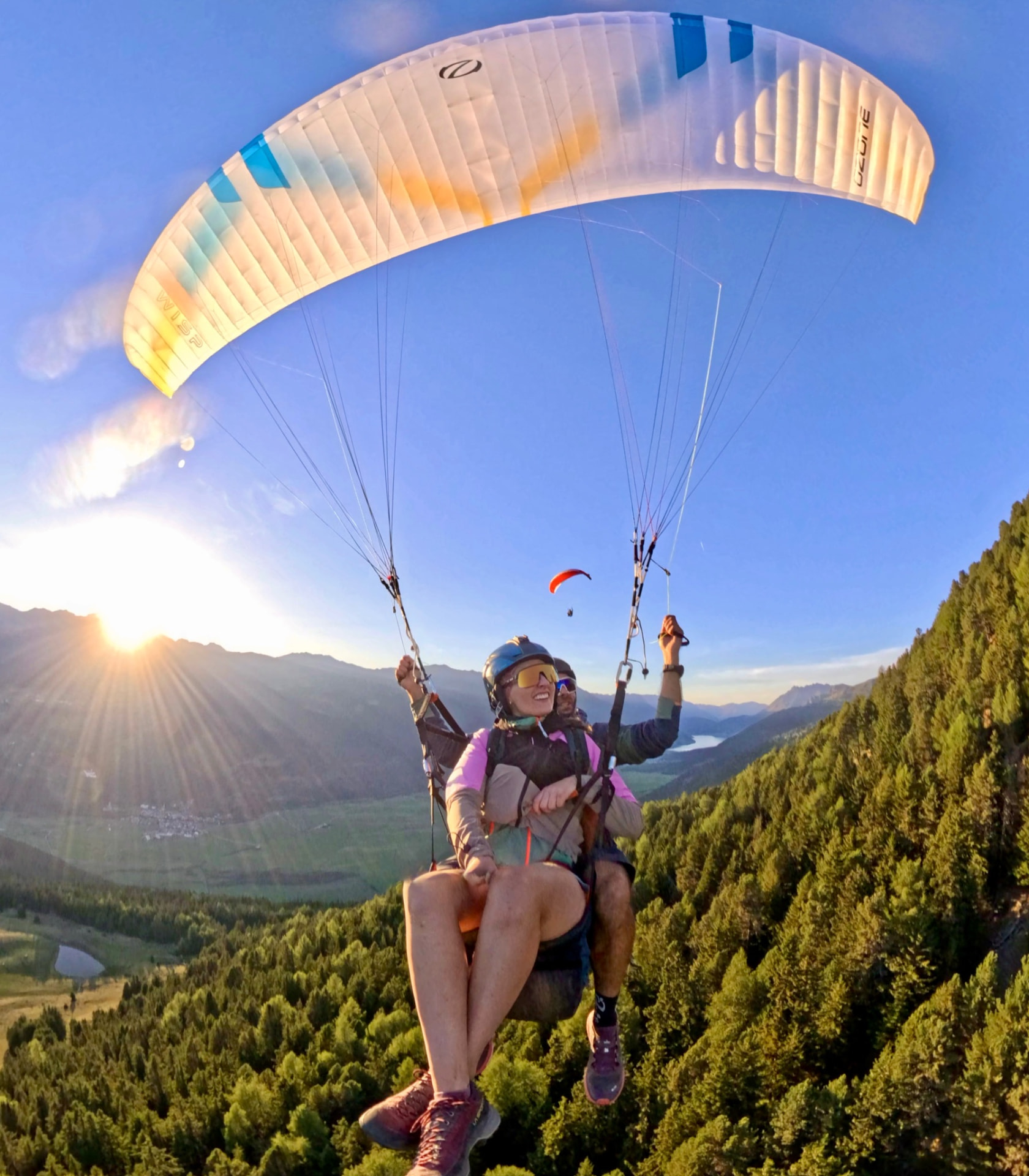 Passagier und Pilot beim Tandemflug im goldenen Abendlicht über dem Vinschgau