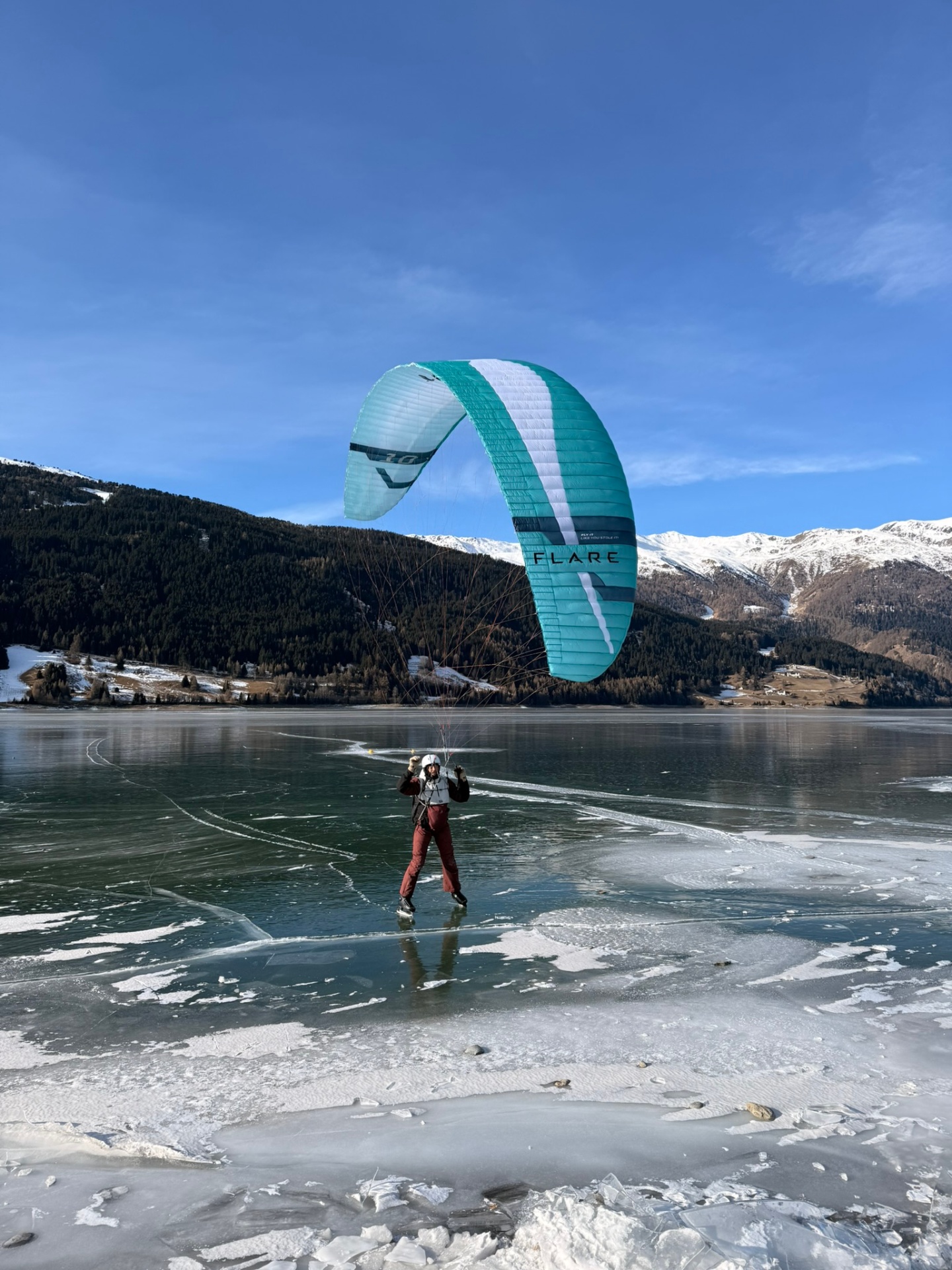 Gleitschirm über dem gefrorenen Reschensee