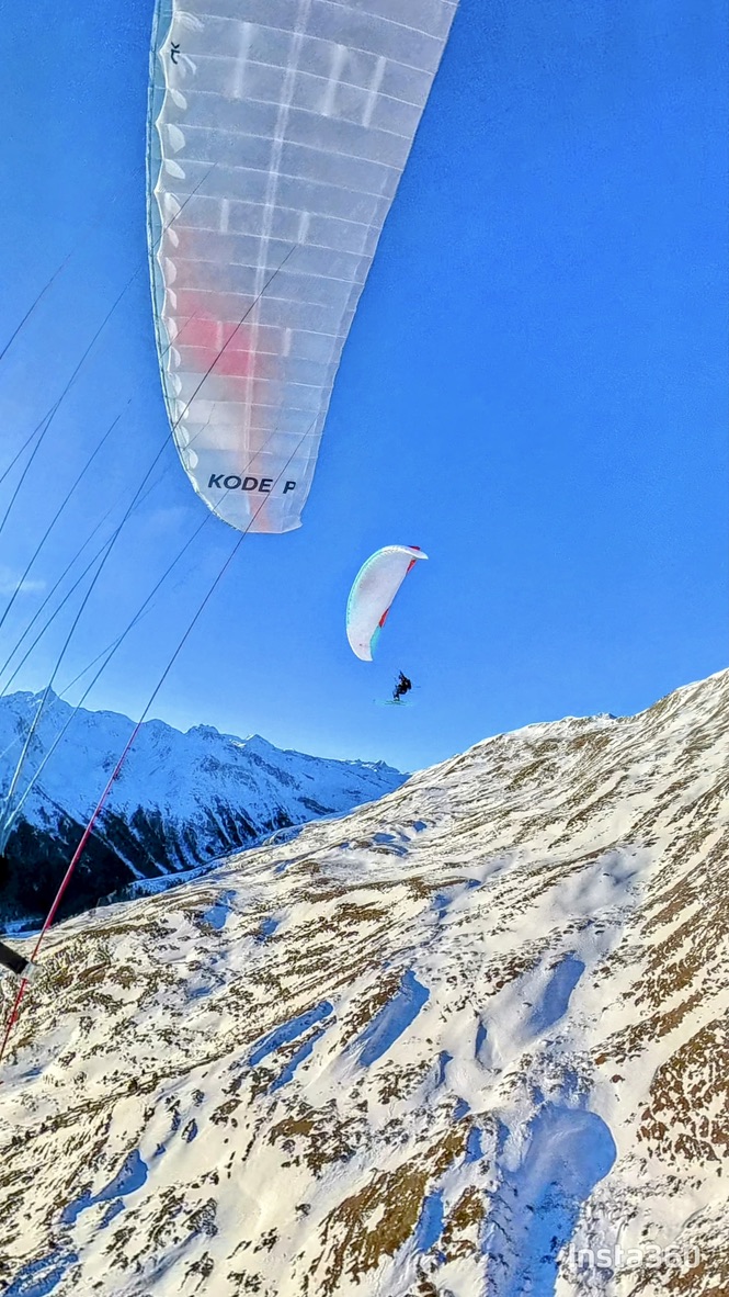 Zwei Gleitschirme über den Schneefeldern in Südtirol