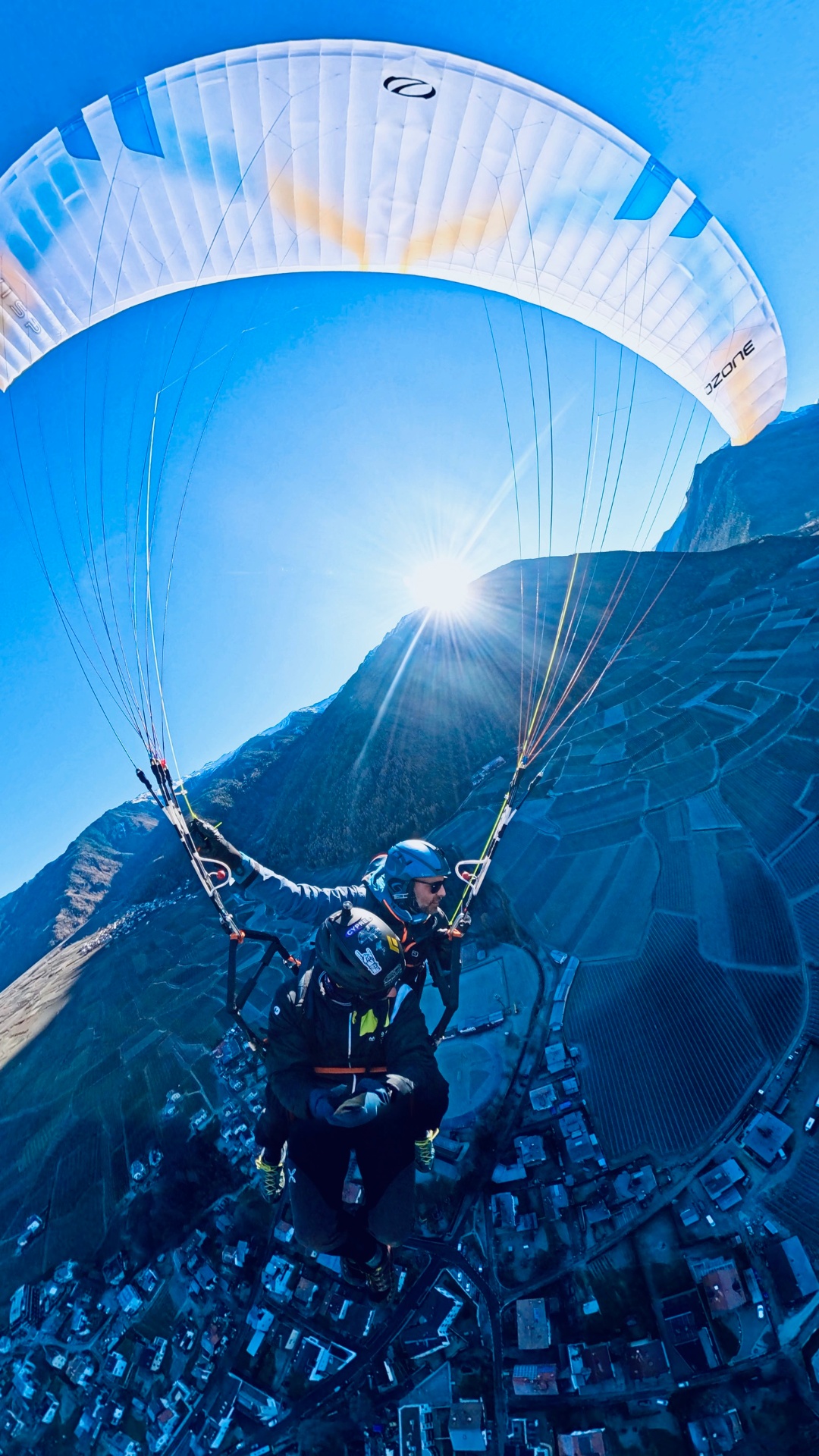 Tandemflug gegen die Sonne hoch über dem Talboden