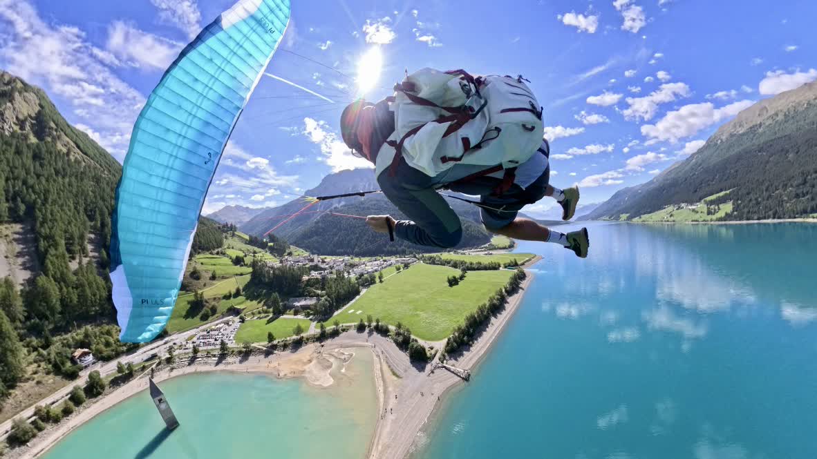 Gleitschirmflug über den Reschensee mit dem versunkenen Kirchturm